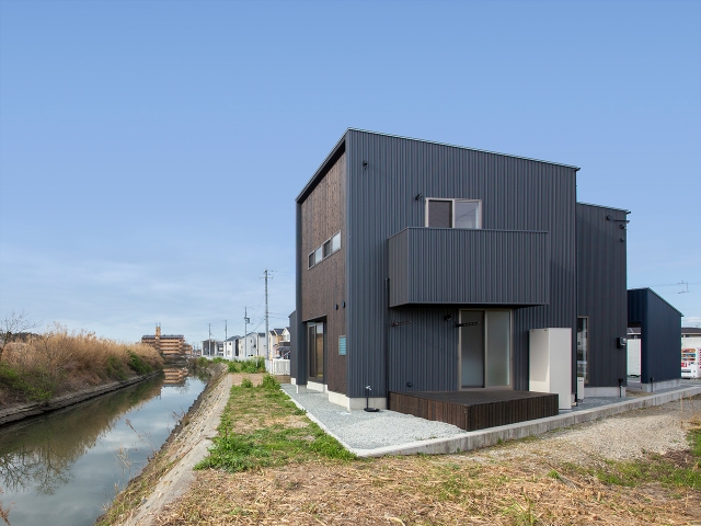 川沿いに建つ片流れ屋根の家　昼景